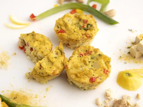 Three eggless frittatas on white surface with green onion garnish