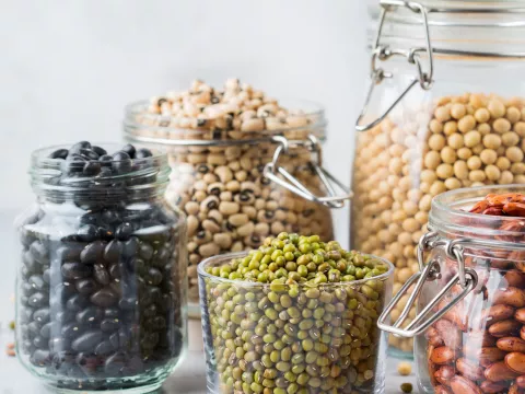 A photo of several jars holding a variety of beans