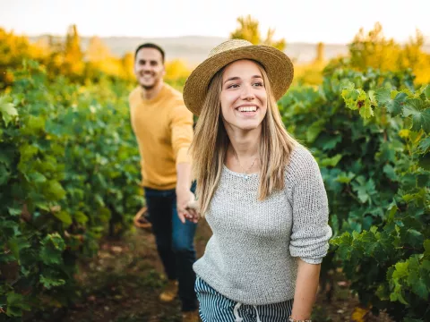 Happy couple walking through a vineyard