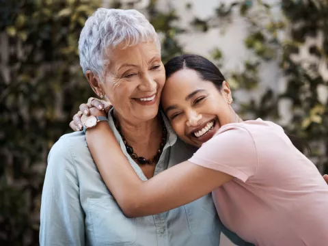 Two Hispanic women hug.