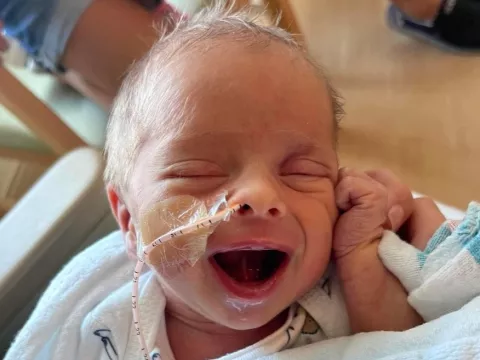 Baby Archer Hanson smiles at the camera from the NICU at AdventHealth Celebration.