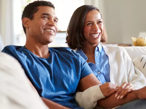 A happy couple on the couch. 