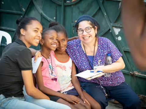 A volunteer woman taking a group photo with Dominican citizens.