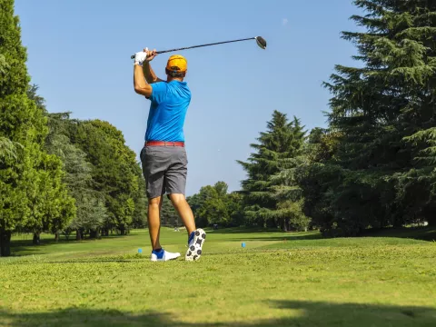 A golfer teeing off.