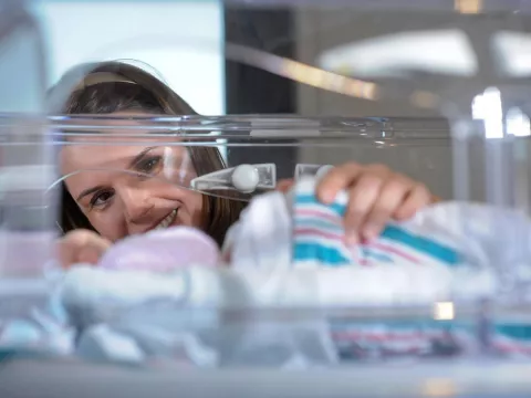 physician supervising a baby