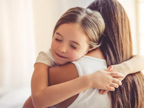 Young child embracing her mother