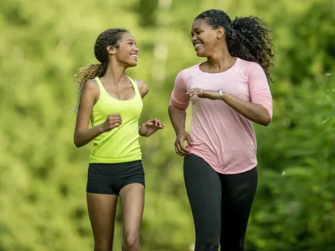 A mother running with her teenage daughter.