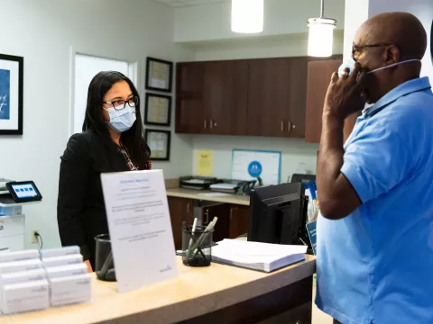 A patient checking in for an appointment and wearing a mask.