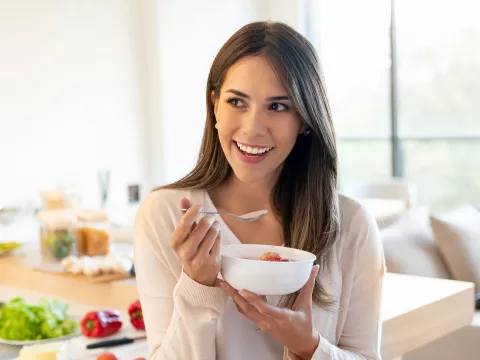 A Young Woman Snacks on Some Yogurt