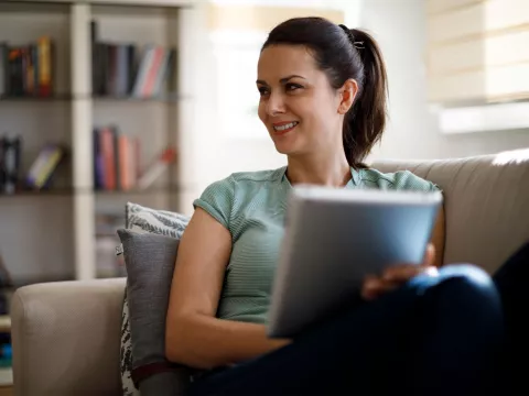 A woman reading on her couch at home.