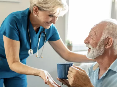 Female nurse talking with a male hospice patient.