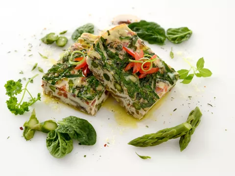 two square slices of a veggie-packed egg frittata