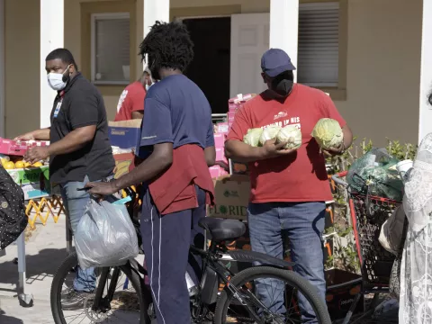 People giving or receiving food at the Mars Hill Community Resource Spot food pantry while outdoors.