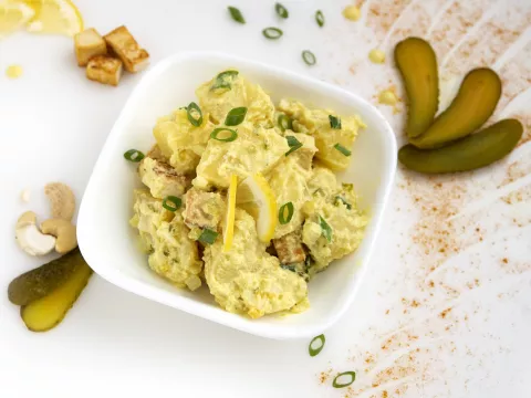 Bowl of potato salad with pickle garnish