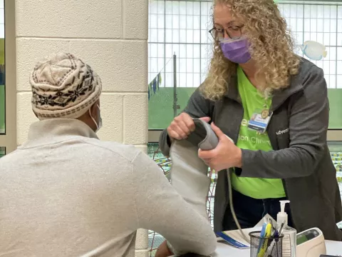 Person receiving medical care by a volunteer at a Chicago Mission Clinic location.