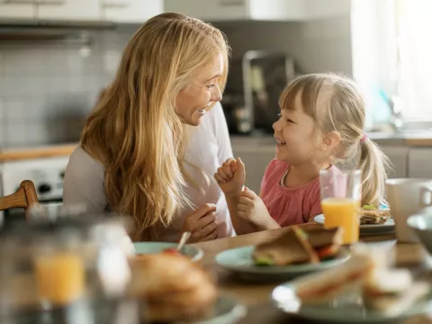 A mother and daughter eating breakfast together.