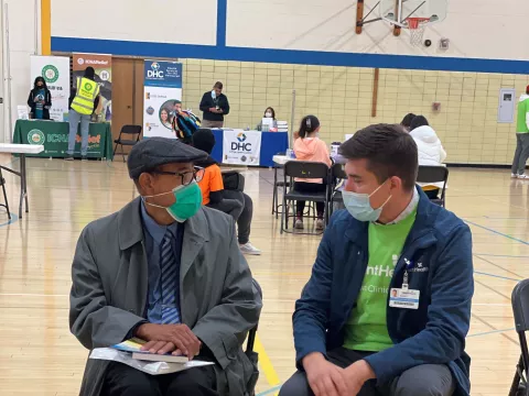 Man talking with a volunteer at a Chicago Mission Clinic location.