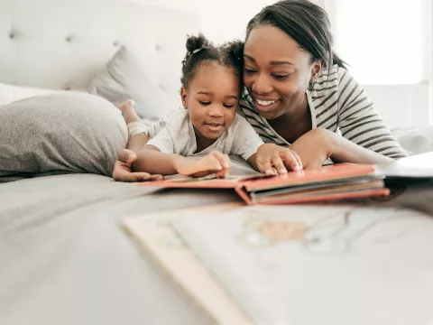 A mother reading to her daughter. 