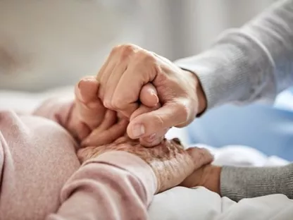 People holding hands at a patient's bedside