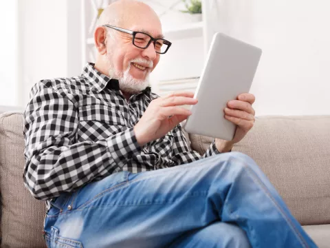 Older man reading on electronic device