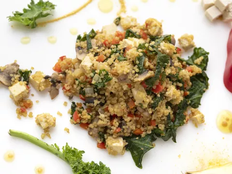 Mound of scrambled tofu with kale garnish on white counter