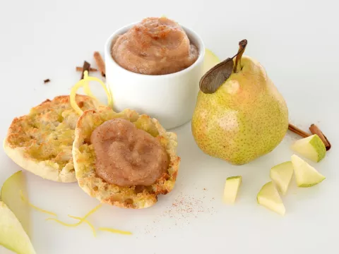 dish and muffin with pear and date sauce next to a whole pear and pear pieces