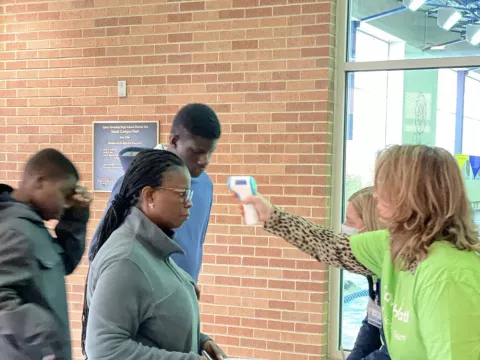 People getting temperature screened during registration at a Chicago Mission Clinic location.