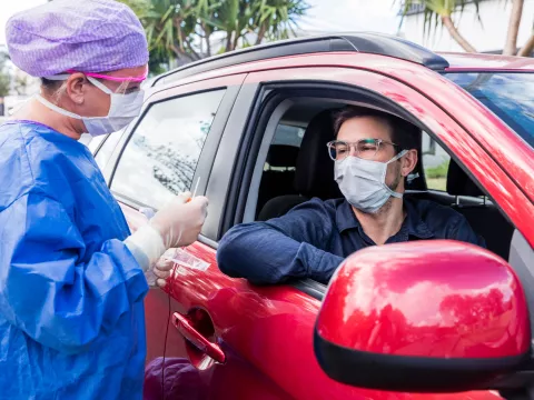 Physician screening man in car