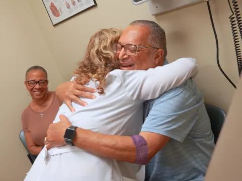 Doctor hugging heart transplant patient.