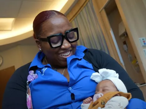 Fourth Trimester care coordinator Erike King holds a baby. 