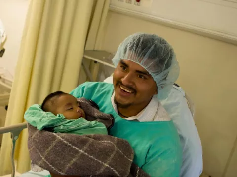 A man holds a baby