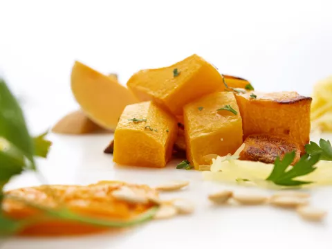 Seven chunks of butternut squash with parsley garnish