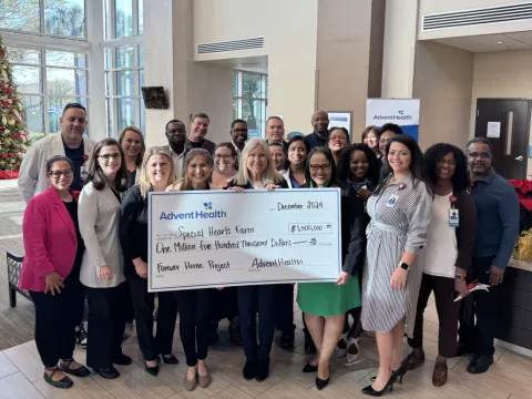 Representatives from Special Hearts Farm and AdventHealth pose with a giant check for $1.5 million.