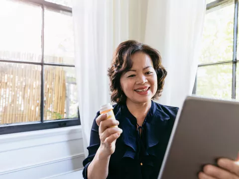 Woman showing her doctor her medication on a tablet.