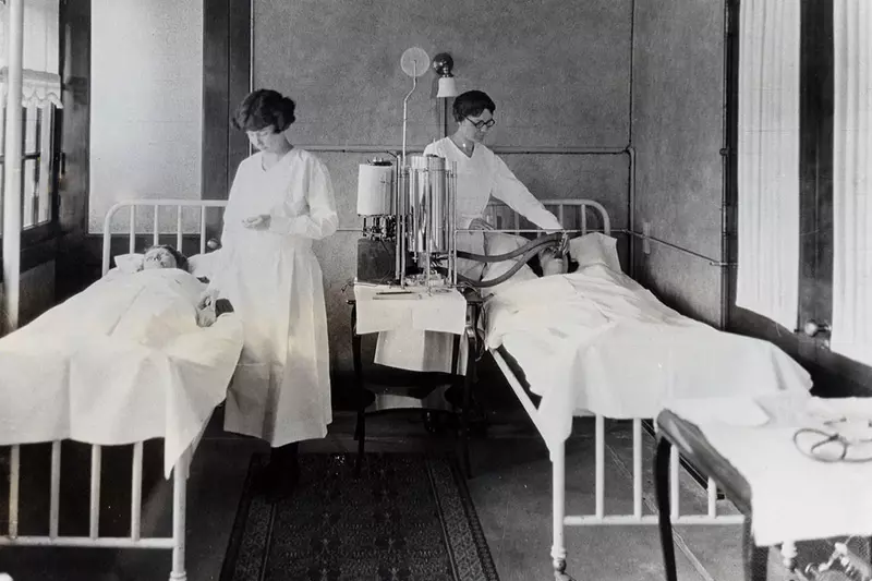 Antique photo of nurses caring for patients.