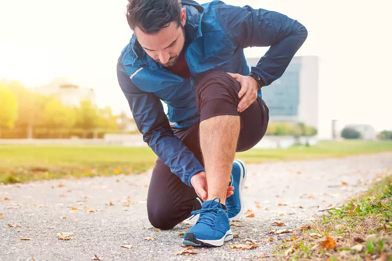 A Jogger Rubs His Ankle While Taking a Break