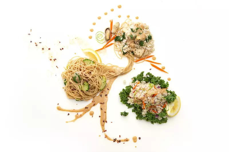 Three mounds of Asian noodles with green garnishes 