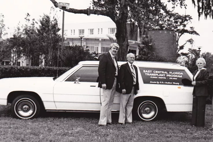 In the 1970s, the first organ procurement automobile was gifted to AdventHealth to help transport kidney donations. Organ procurement coordinators gather around the new vehicle with the generous community members who made the gift. (Dr. Metzger is not pictured.)
