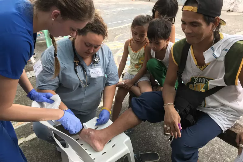 Volunteers with a patient in the Philippines