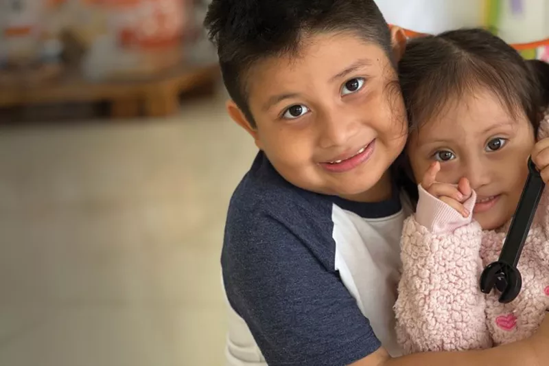 a boy hugging his sister