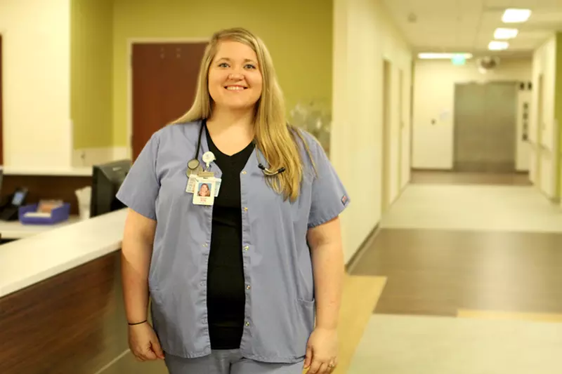 A white woman standing in a hall at the hospital 