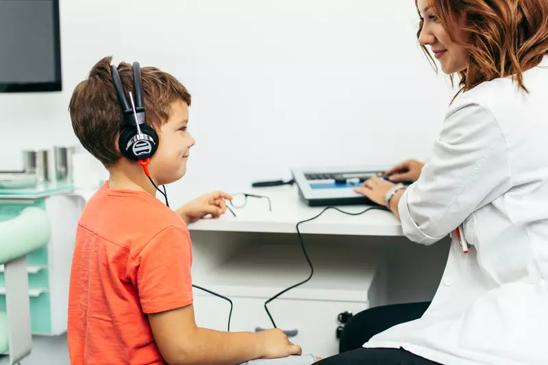 A boy getting a hearing test from a doctor.