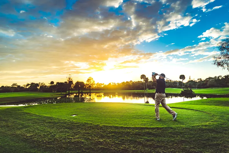A Man Tees Off on a Florida Golf Course