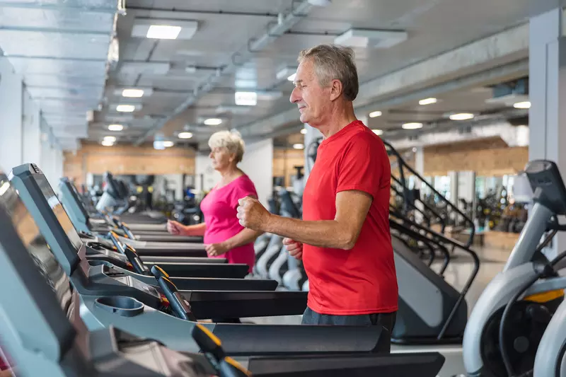A senior man and woman doing cardiovascular rehabilitation on a treadmill