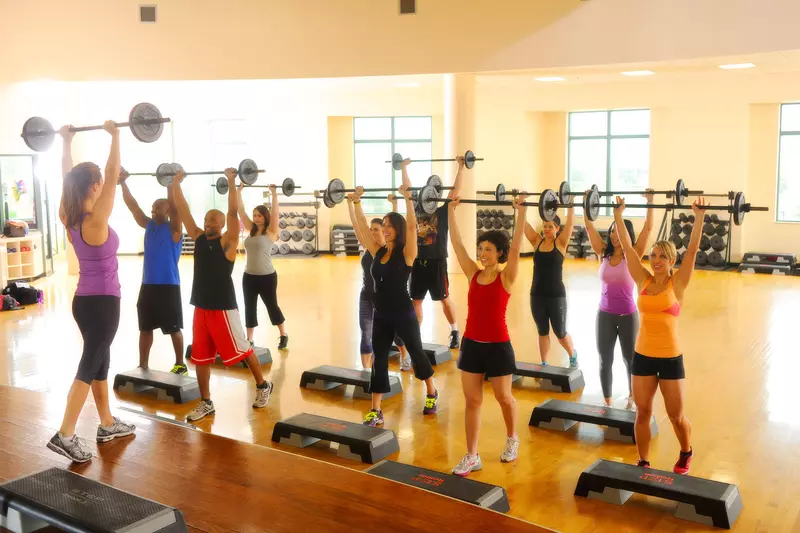 A group of people lighting weights at a fitness class. 