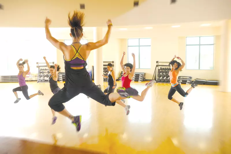 A group of women exercising at the gym while doing a group class. 