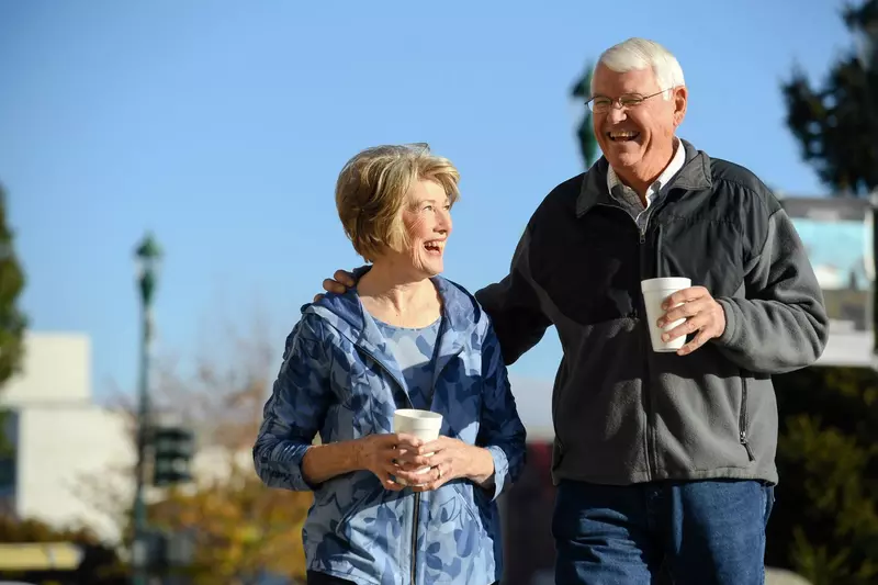 Elderly man and woman walking together in town