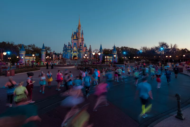 Runners running runDisney event at Magic Kingdom in front of Cinderella's Castle.
