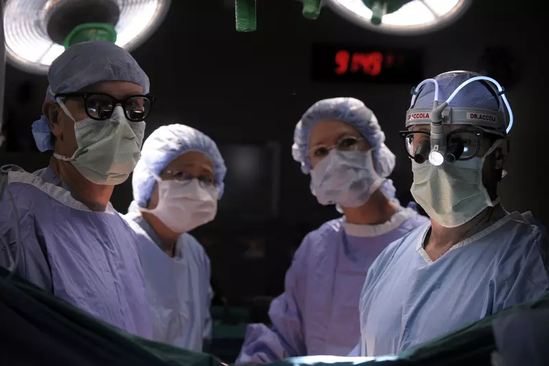 Doctor and staff in an Operating Room, facing camera, ready for surgery