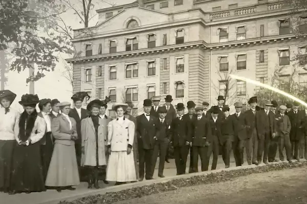 Black and white historical photo of people standing in front of a Sanitarium